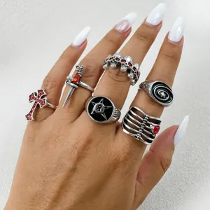 Detalle de primer plano de anillos punk góticos vintage con calavera cruz y daga