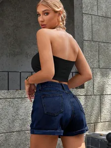 Vista posteriore dettagliata di pantaloncini di jeans blu scuro a vita alta con orli risvoltati
