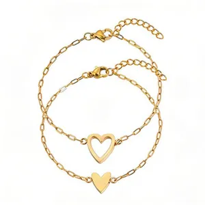 Detailed view of two gold stainless steel heart bracelets on white background