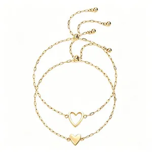 Detail showing two gold stainless steel bracelets with hollow and solid heart charms
