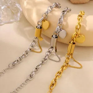 Detail showing stainless steel chain bracelets with gold and silver heart charms in warm light