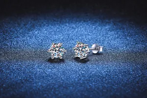Primo piano di classici orecchini a lobo in argento S925 con sei griffe e moissanite