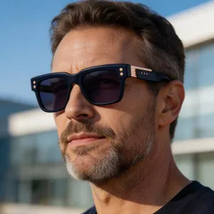 Close-up of stylish square sunglasses with rose gold accents worn by a male model.