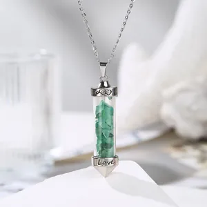 Close-up of a silver pendant necklace filled with green natural crystal stones