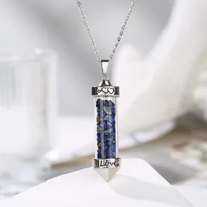 Detailed macro view of a silver necklace with lapis lazuli stone pendant and Love engraving
