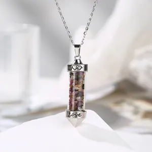 Detailed close-up of a cylindrical pendant filled with colorful natural crystal gravel.