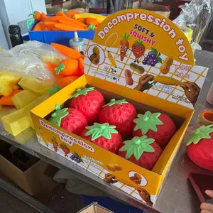 Close-up of strawberry-shaped squeeze toys arranged in a yellow retail display package