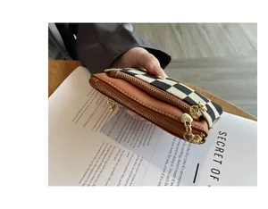 Detailweergave van de multifunctionele portemonnee met drie ritsen en ruitjespatroon
