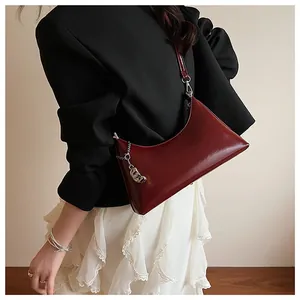 Detailansicht der burgunderroten Vintage-Achseltasche getragen von einem Model