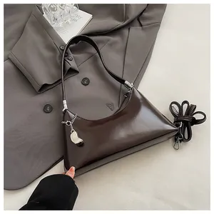 Detailansicht einer dunkelbraunen, glänzenden Vintage-Hobo-Tasche mit Silberkette