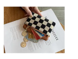 Gedetailleerd overzicht van een portemonnee met dambordpatroon met kaarten en munten