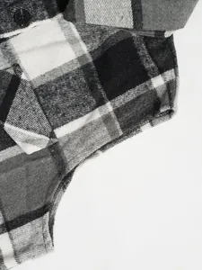 Close-up macro view of black and white plaid woolen vest showing fabric texture and seams