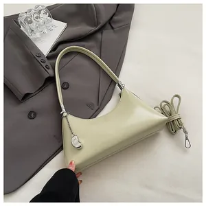 Detailaufnahme der minimalistischen salbeigrünen Achseltasche mit silbernem Anhänger