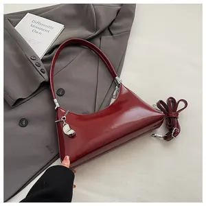 Detailansicht einer glänzend dunkelroten Hobo-Tasche mit silbernem Herzanhänger