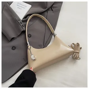 Beigefarbene Vintage-Unterarmtasche mit elegantem Metallanhänger-Detail