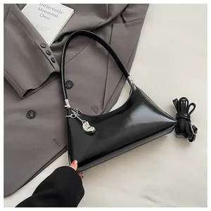 Elegante schwarze Vintage-Achseltasche mit silbernem Bohnenanhänger und Trageriemen.