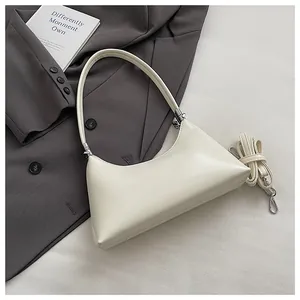 Nahaufnahme einer minimalistischen cremeweißen Schultertasche mit abnehmbarem Gurt