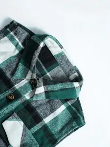 Detailed close-up of the collar and green plaid texture on a soft woolen vest jacket