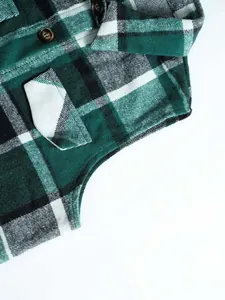 Macro detail view of green plaid wool sleeveless vest showing premium fabric texture and buttons