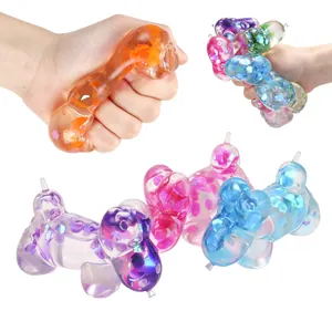 Close-up of colorful balloon dog squishy toy with glitter being squeezed by hand.
