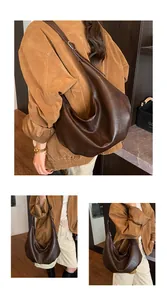 Detailansicht einer braunen Vintage Hobo-Tasche mit großem Fassungsvermögen am Modell