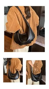 Detailansicht einer großen schwarzen Leder-Hobo-Tasche kombiniert mit einer braunen Jacke