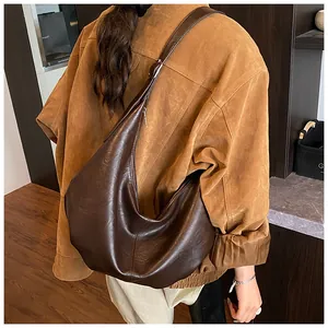 Detailansicht einer großen dunkelbraunen Hobo-Tasche im Vintage-Stil mit Wildlederjacke