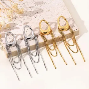 Detailansicht goldener und silberner unregelmäßiger ovaler Ohrstecker mit Kettenquasten