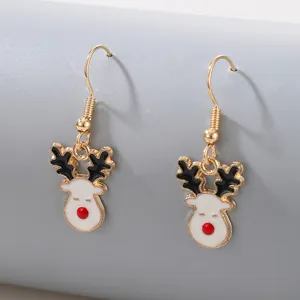 Gros plan de boucles d'oreilles rennes de Noël avec crochets dorés et nez rouge