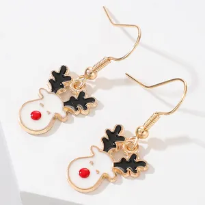 Détail macro des jolies boucles d'oreilles renne de Noël avec nez rouge et crochet doré