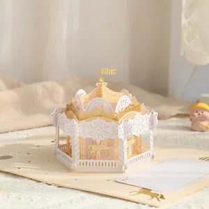 Detailweergave van een 3D pop-up carrousel wenskaart met elegante goudstempel.