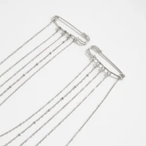 Gros plan de broches à chaîne à franges argentées au design minimaliste d'épingle à nourrice