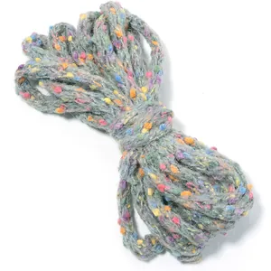 Close-up of grey speckled yarn with colorful dots for DIY knitting and craft projects.