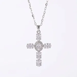 Vintage silver cross necklace featuring sparkling oval cubic zirconia stones on white.