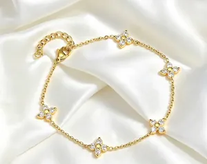 Dettaglio di un bracciale in oro e acciaio con fiori di zirconi su seta bianca.