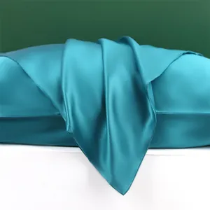 Detailopname van 22 momme 100% moerbeizijde kussensloop met luxe groenblauwe textuur.