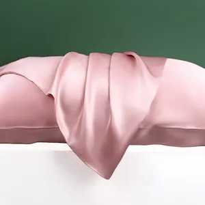 Detailopname van roze 100% moerbeizijde kussensloop met glanzende textuur