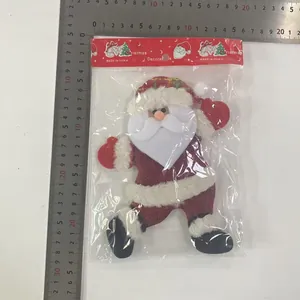 Close-up detail of plush fabric Santa Claus ornament showing size measurements with a metal ruler