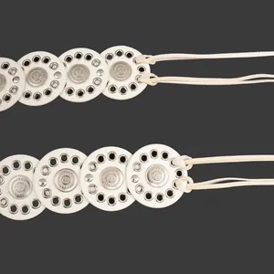 Detailed close-up of a white vintage ethnic style wide belt with decorative metal studs