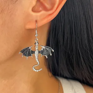 Detailaufnahme eines antiken silbernen Drachenohrrings mit schwarzen Emailleflügeln