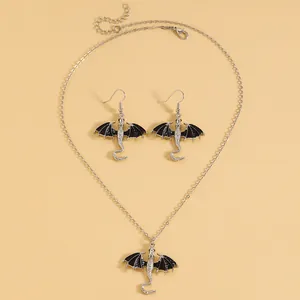 Detailansicht eines silbernen Drachen-Schmucksets mit Halskette und Ohrringen in schwarzem Emaille.