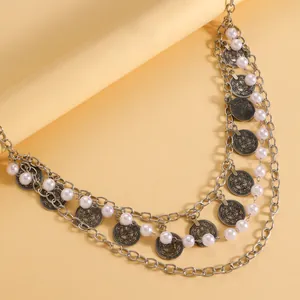 Detail view of multi-layered bohemian waist chain with faux pearls and coin pendants