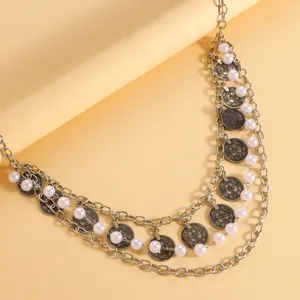 Detailed macro view of Bohemian ethnic style silver waist chain with pearls and coin charms