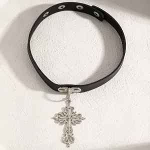 Close-up detail of a black leather gothic choker with an ornate silver cross pendant