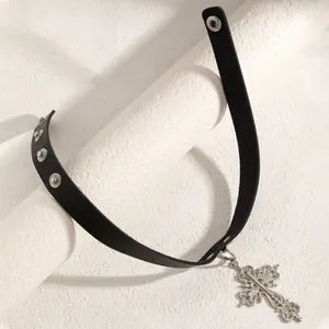 Close-up of black leather choker with vintage silver cross pendant and snaps