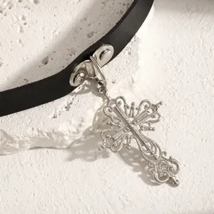 Detailed view of an ornate silver cross pendant on a black leather Y2K choker collar.