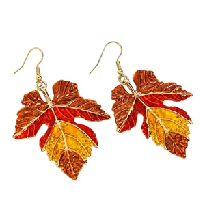 Detailed close-up of vibrant enamel maple leaf earrings with fall gradient