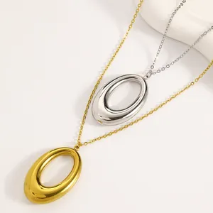 Detailed close-up of polished gold and silver oval pendant necklaces in titanium steel
