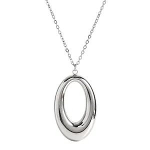 Close-up view of a sleek silver-toned oval pendant on a delicate link chain necklace.