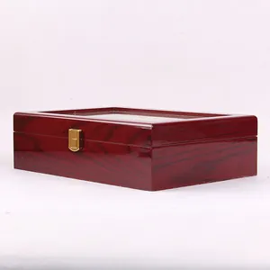 Close-up of a premium dark red wooden watch display box with glossy lacquer finish.
